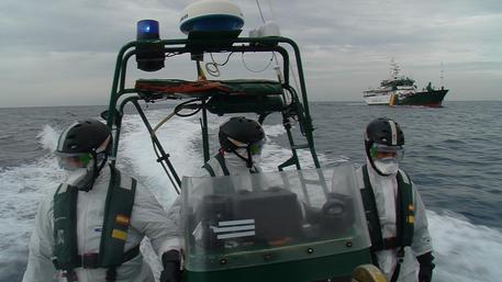 FOTO DI SALVATORE LUSSU Membri dell'equipaggio della nave della Guardia Civil spagnola Rio Mino, impegnata nella missione  Triton, su una scialuppa veloce, equipaggiati con le tute anti Ebola. © ANSA