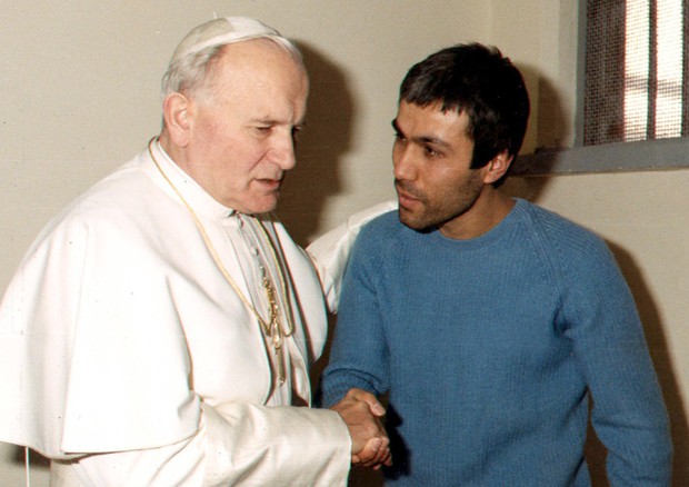 Giovanni Paolo II parla con il suo attentatore Mehmet Ali Agca nel carcere di Rebibbia in una foto del 1983 © ANSA