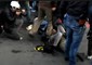 In un frame da un video esclusivo di 'Servizio Pubblico', la telecamera registra il momento in cui un agente di polizia appoggia un piede sulla pancia di una ragazza durante le proteste del corteo del 12 aprile a Roma © Ansa
