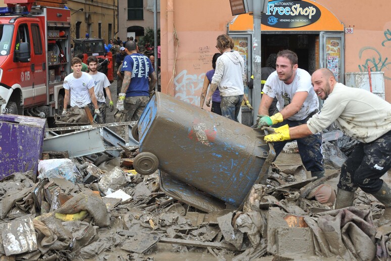 Volontari al lavoro per liberare le strade dal fango dopo l 'alluvione che ha colpito Genova, 11 ottobre 2014 - RIPRODUZIONE RISERVATA