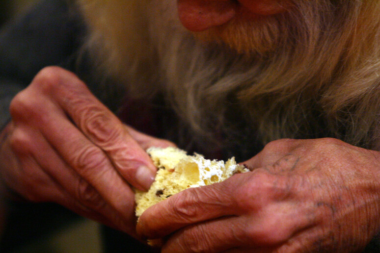 Un uomo durante  il pranzo di Natale allestito dalla Comunita ' di Sant 'Egidio (archivio) - RIPRODUZIONE RISERVATA
