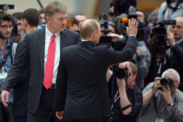 Vladimir Putin (C) e Dmitry Peskov (s) - RIPRODUZIONE RISERVATA